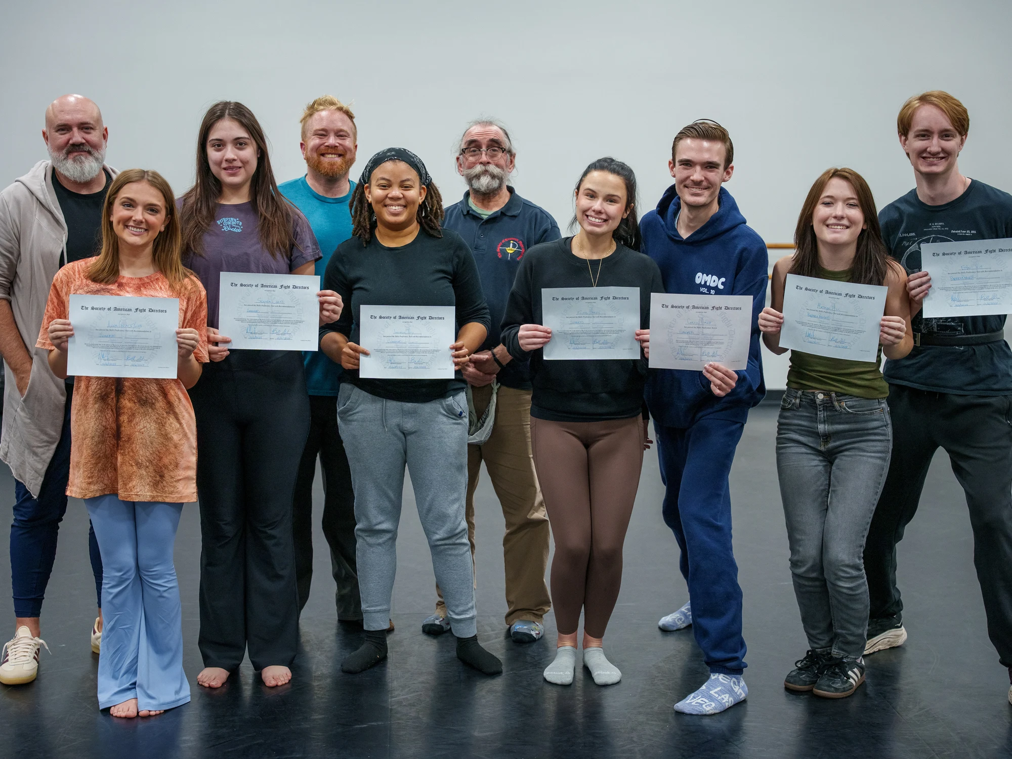 A group holding awards and certificates outdoors.